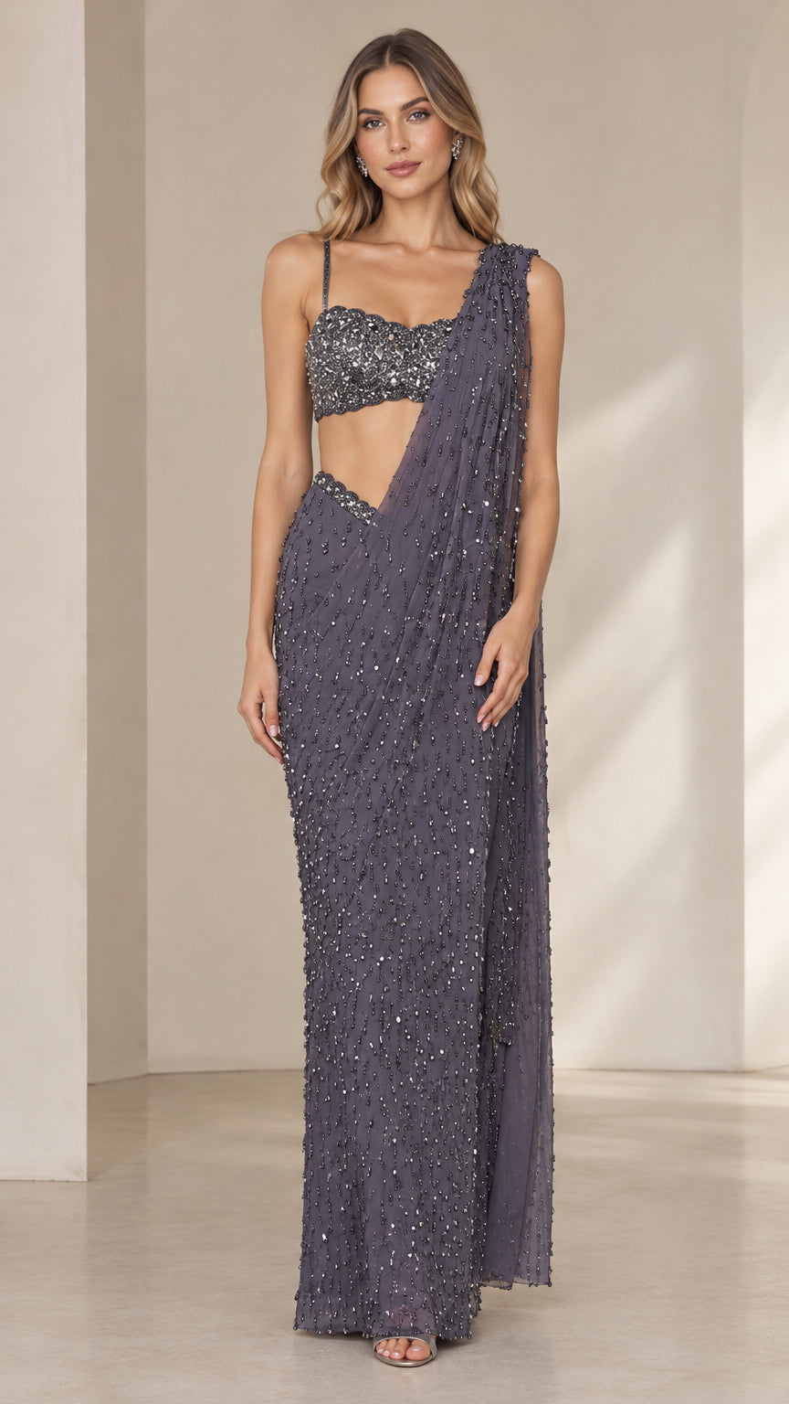 Front view of model wearing charcoal sequined pre-draped saree gown set with cropped bustier