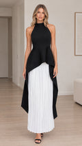 Front view of model wearing black halter high-low peplum maxi dress with white pleated skirt