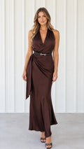 Front view of woman wearing chocolate brown halter neck wrap satin maxi dress with belted side drape