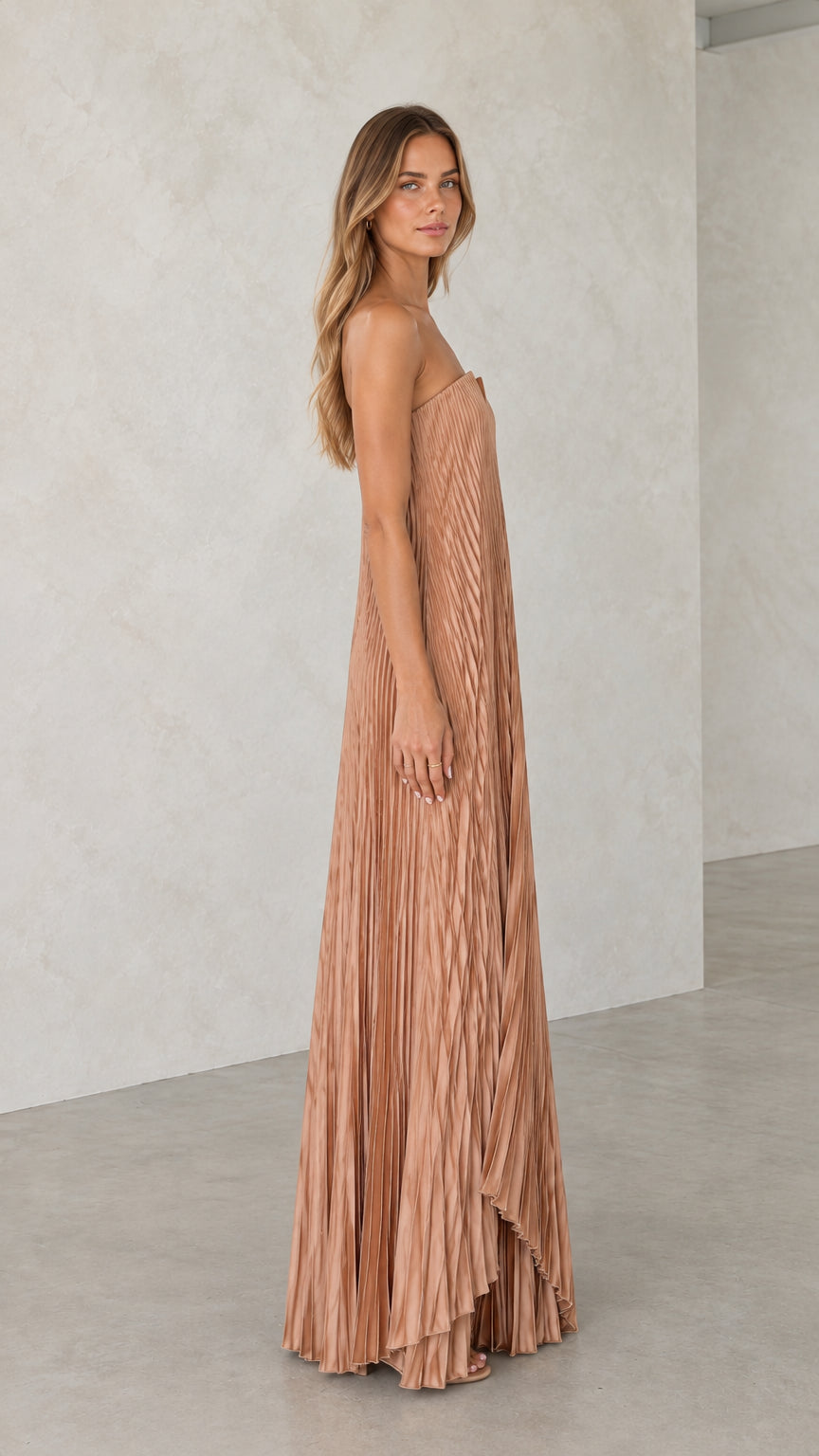Side profile view of champagne pleated strapless floor-length gown