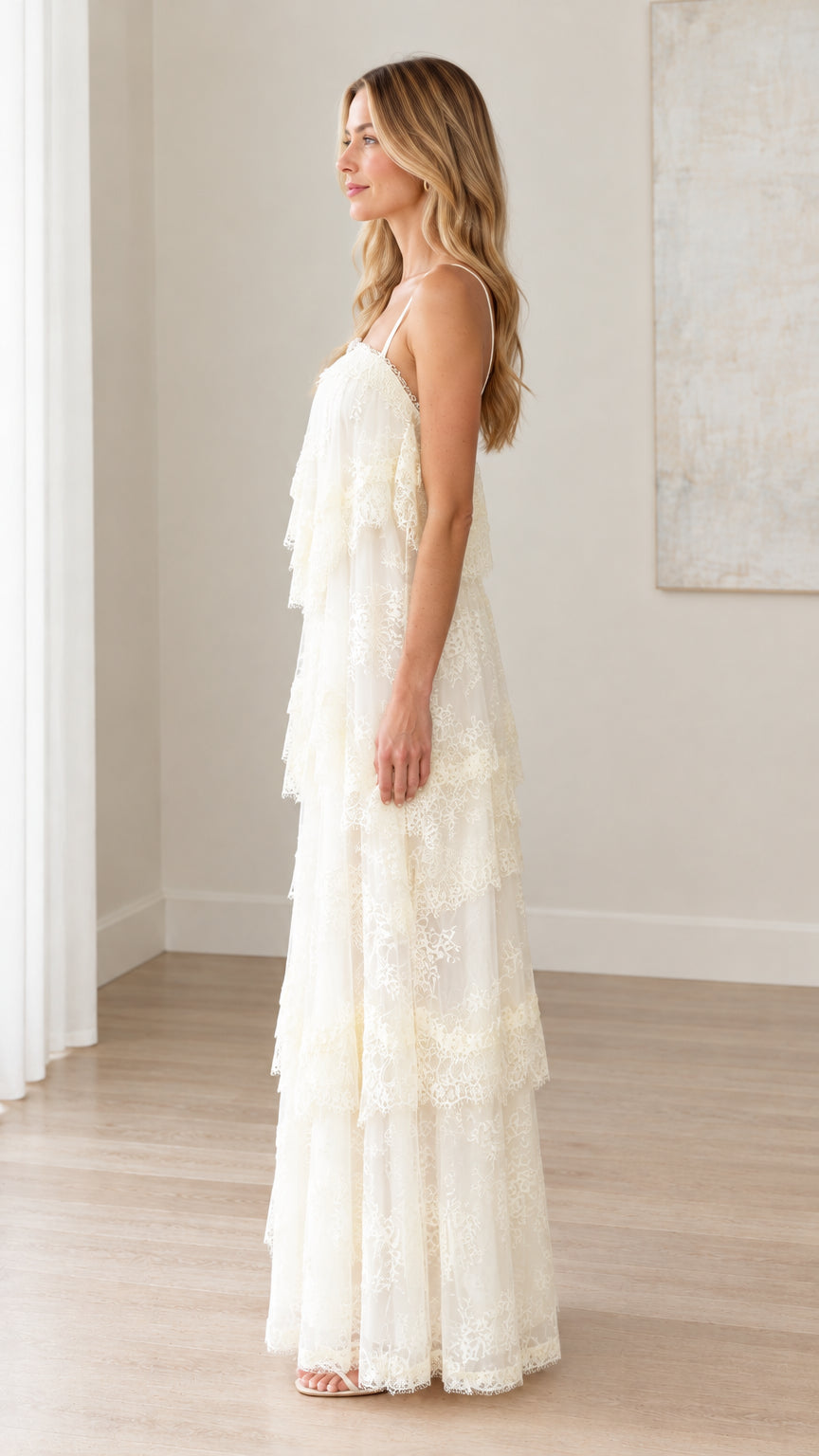 Side full-length profile of woman modeling cream tiered lace maxi dress