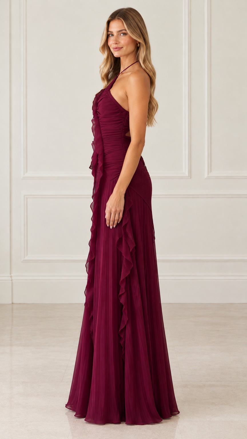 Side profile of woman in burgundy tiered ruffle halter maxi dress