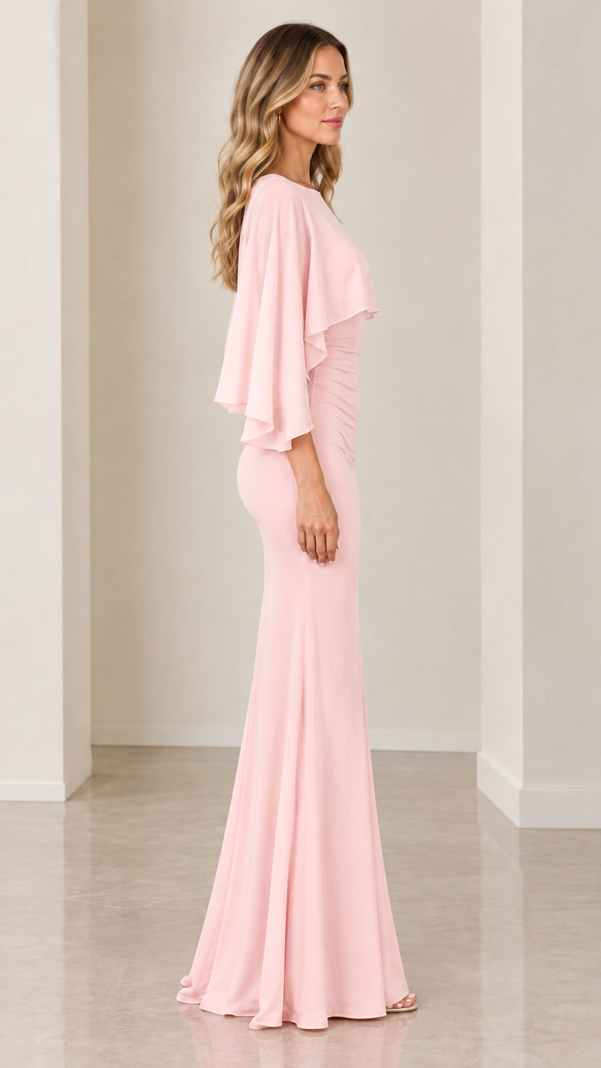 Side profile of blush pink capelet maxi dress highlighting ruched waist and drape