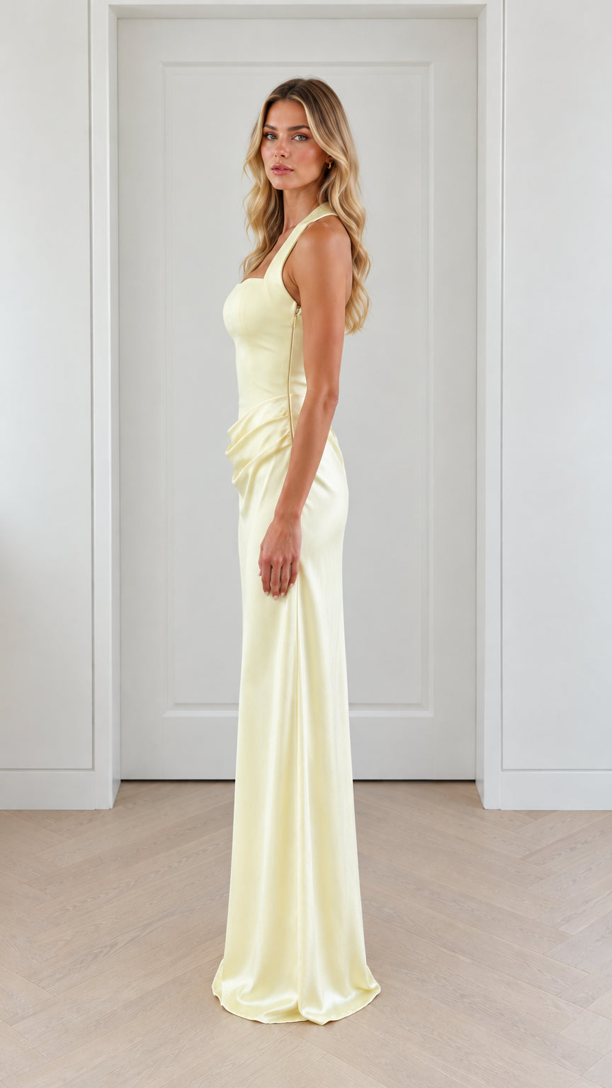 Side profile view of pale yellow halter neck ruched maxi evening dress