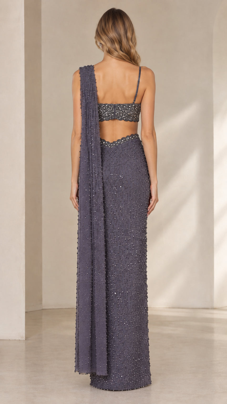 Back view of model wearing charcoal sequin bustier top and pre-draped floor-length skirt