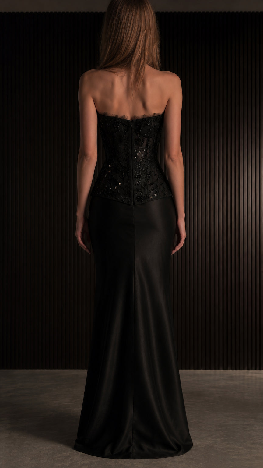 Back view of black strapless corset top and floor-length satin skirt