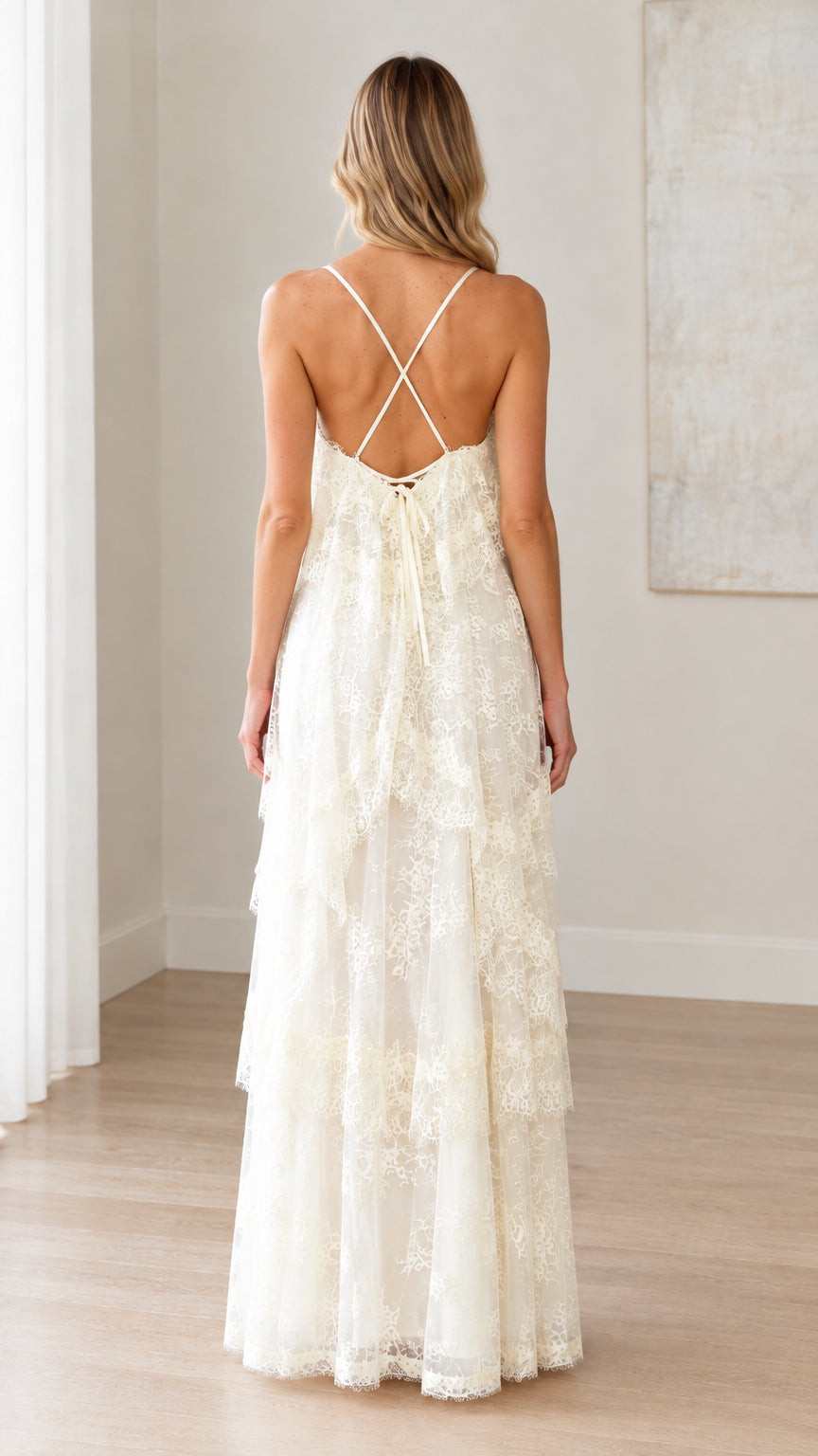 Back full-length view of woman showing open back and crisscross tie straps on ivory lace maxi dress
