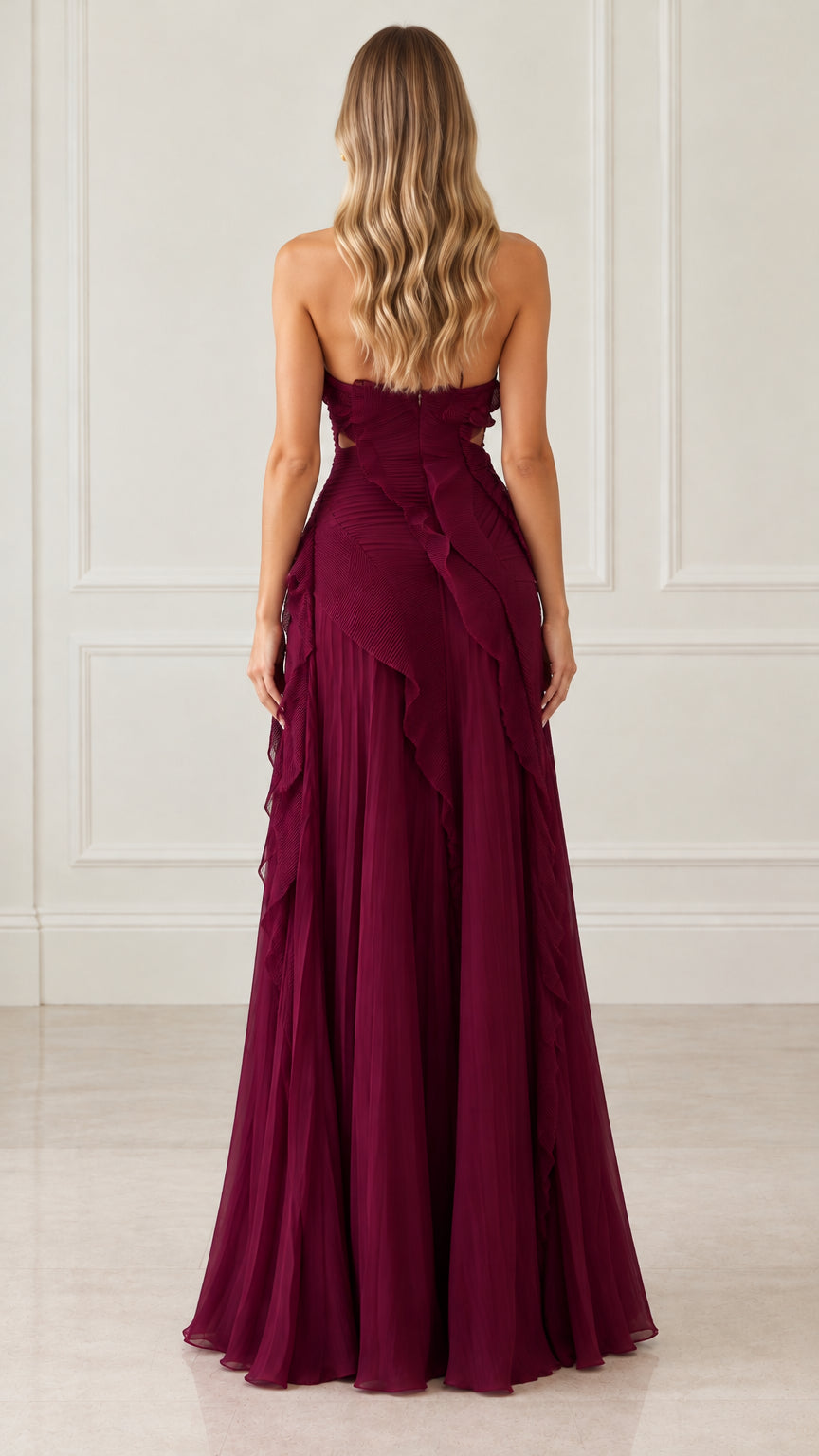 Back view of woman in burgundy halter neck pleated evening dress showing open back