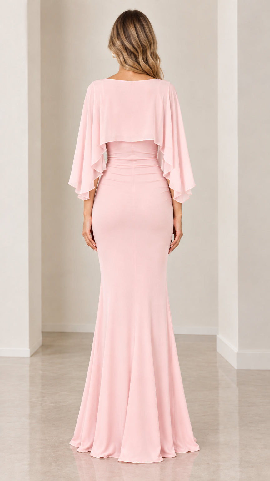 Back view of blush pink floor-length mermaid gown with cape overlay