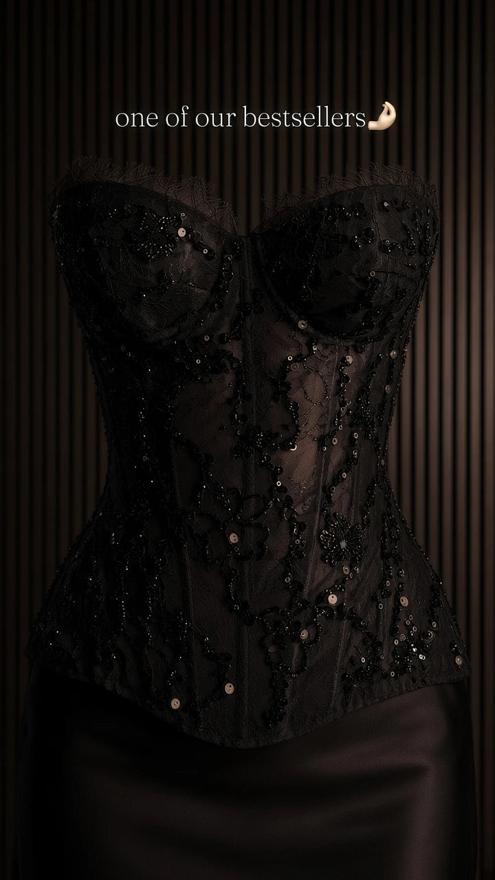 Close-up detail of black corset top showing boning, lace, and sparkling sequins