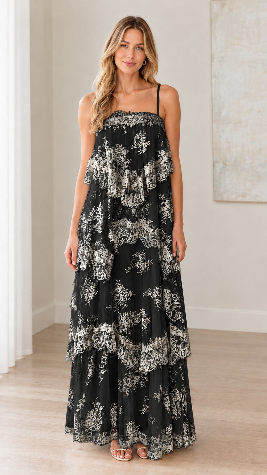 Front full-length view of woman wearing black tiered floral lace maxi dress with spaghetti straps