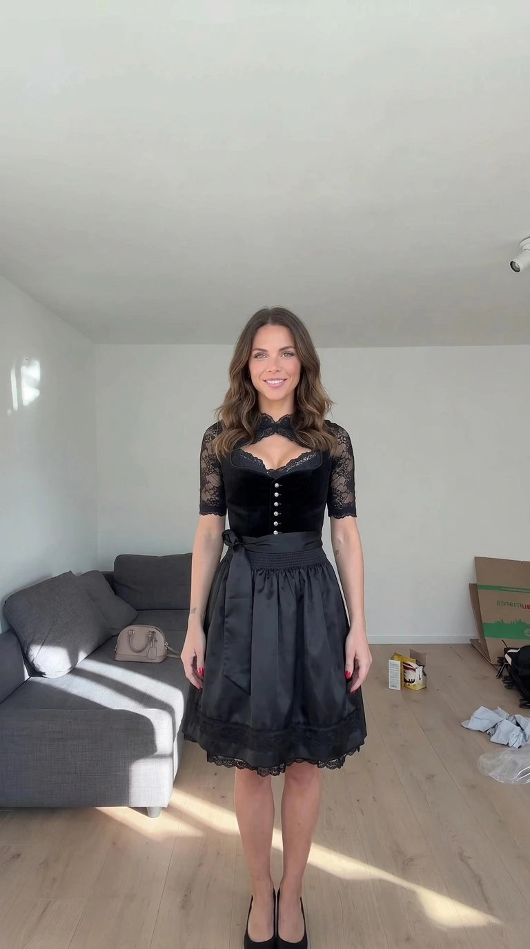 Front view of model wearing Black velvet dirndl dress with black lace blouse and matching apron