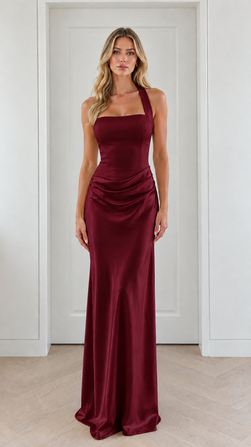Front view of model wearing burgundy halter neck ruched satin maxi gown