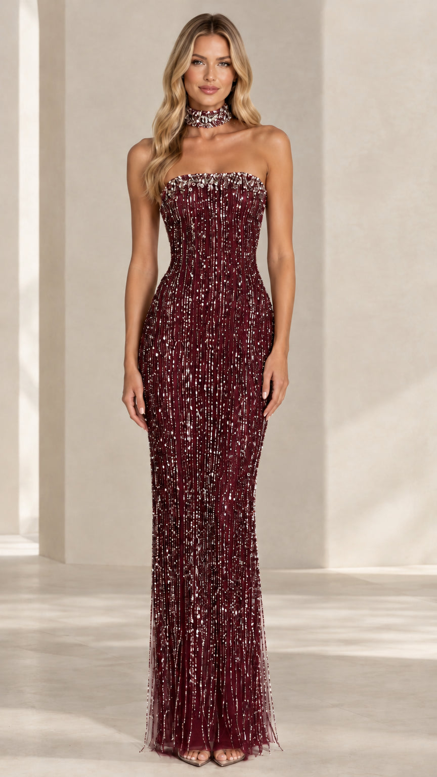 Model wearing a burgundy wine red strapless sequin fringe formal maxi dress with choker
